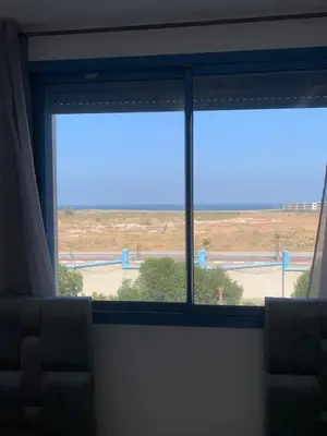 a window in a room with a view of a field at Résidence Perla Andalusia Vue Sur Mer in Mansouria