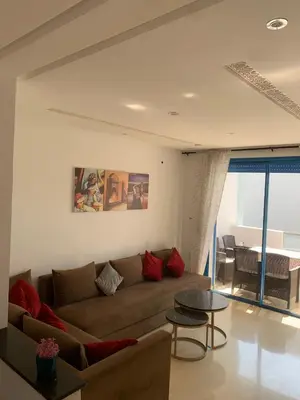 a living room with a couch and a table at Résidence Perla Andalusia Vue Sur Mer in Mansouria