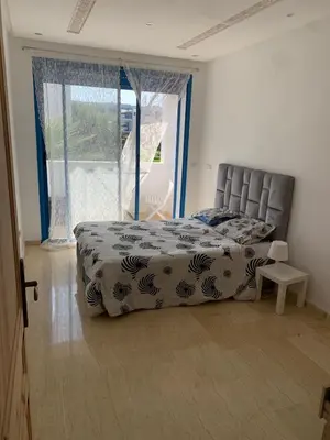 a bedroom with a bed and a large window at Résidence Perla Andalusia Vue Sur Mer in Mansouria