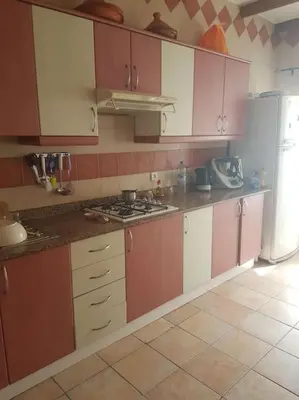 a kitchen with pink and white cabinets and a refrigerator at Appartement lumineux by Moon in Casablanca