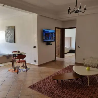 a living room with two tables and a tv on the wall at Appartement lumineux by Moon in Casablanca