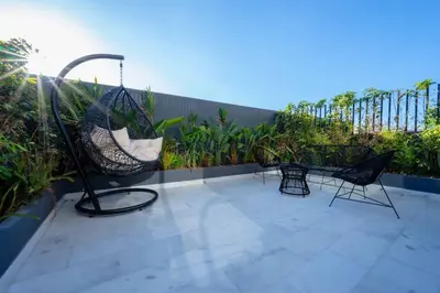 a patio with chairs and a swing on a balcony at Luxe Modern Studio in Casablanca in Casablanca