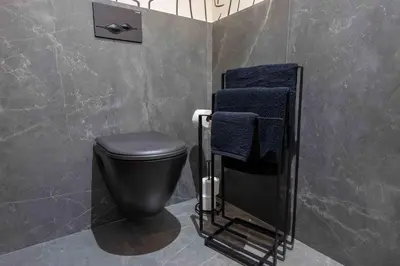 a bathroom with a black toilet and blue towels at Luxe Modern Studio in Casablanca in Casablanca