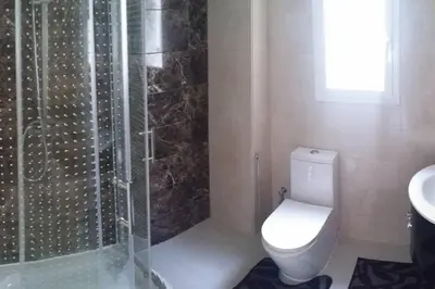 a bathroom with a shower and a toilet and a sink at Appartement Haut Standing - Bouznika plage in Bouznika