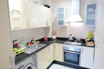 a small kitchen with a sink and a stove at Appartement Haut Standing - Bouznika plage in Bouznika