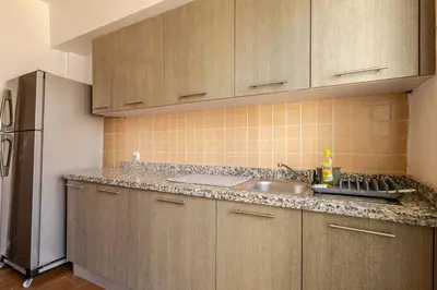 a kitchen with wooden cabinets and a sink and a refrigerator at New! Appartement les pieds dans l'eau WELCOME STAY in Pont Blondin
