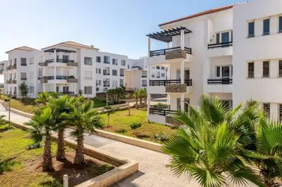an apartment complex with palm trees and buildings at New! Appartement les pieds dans l'eau WELCOME STAY in Pont Blondin