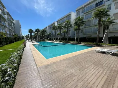 a swimming pool in front of a building at Sublime appart piscines & espaces jeux, proche mer in Bouznika
