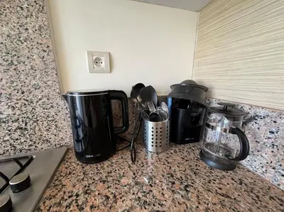 a counter top with coffee pots and utensils on it at Sublime appart piscines & espaces jeux, proche mer in Bouznika