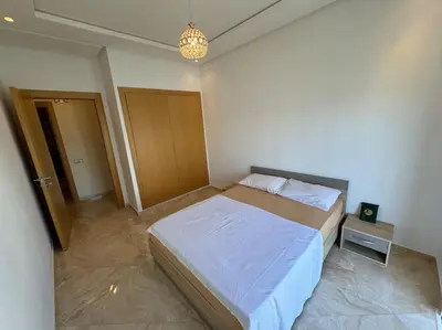 a bedroom with a large bed in a room at Sublime appart piscines & espaces jeux, proche mer in Bouznika