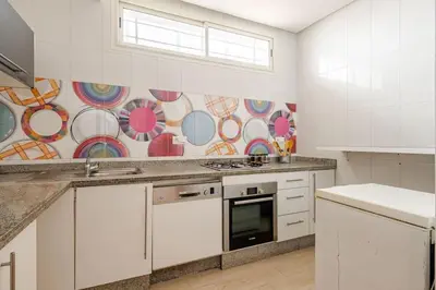 a kitchen with white cabinets and a stove top oven at Beachfront Escape - Panoramic View and Spacious Terrace in Skhirat