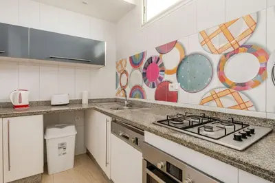 a kitchen with a sink and a stove top oven at Beachfront Escape - Panoramic View and Spacious Terrace in Skhirat
