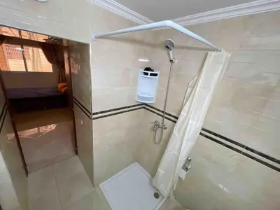 a bathroom with a shower with a shower curtain at Spacious & Comfy Moroccan Apartment in Temara