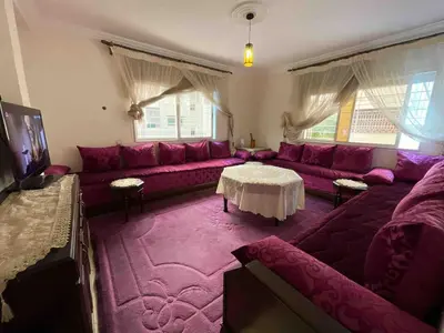 a living room with a purple couch and a table at Spacious & Comfy Moroccan Apartment in Temara