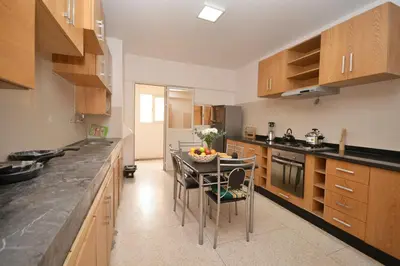 a kitchen with a table with a bowl of fruit on it at Spacious Haven in Abdelmoumen in Casablanca