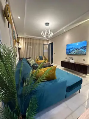 a living room with a blue couch and a tv at Stylish Appartement Lumineux et Luxueux Au Coeur De Maarif Quartier Palmier Près De Station Tramway & Bd Abdelmoumen Casablanca in Casablanca