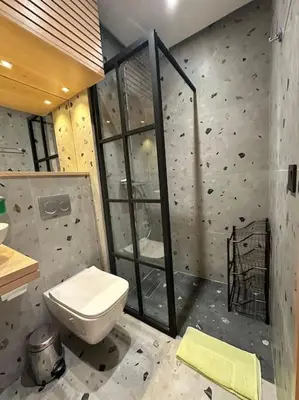 a bathroom with a toilet and a rock wall at Stylish Appartement Lumineux et Luxueux Au Coeur De Maarif Quartier Palmier Près De Station Tramway & Bd Abdelmoumen Casablanca in Casablanca