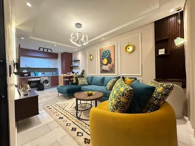 a living room with a blue couch and a yellow chair at Stylish Appartement Lumineux et Luxueux Au Coeur De Maarif Quartier Palmier Près De Station Tramway & Bd Abdelmoumen Casablanca in Casablanca