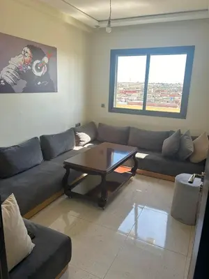 a living room with a couch and a coffee table at Appartement à Sidi Rahal - 5 min de la plage in Sidi Rahal