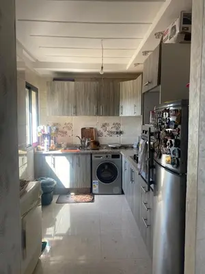a kitchen with a refrigerator and a dishwasher at Appartement à Sidi Rahal - 5 min de la plage in Sidi Rahal