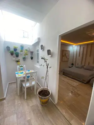 a room with a bedroom with a table and a plant at Un écrin rabati in Rabat