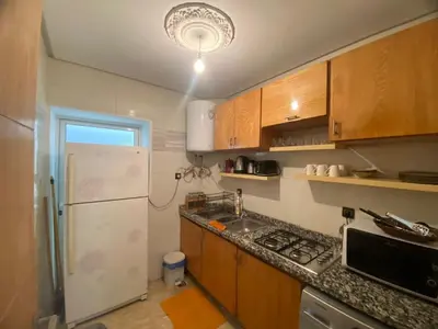 a kitchen with wooden cabinets and a white refrigerator at Un écrin rabati in Rabat