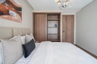 a bedroom with a white bed and a chandelier at Beautiful 1 Bedroom Appartment in Anfa in Casablanca