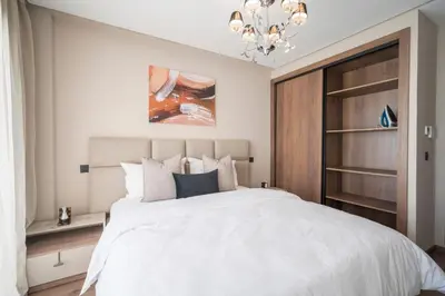 a bedroom with a white bed and a chandelier at Beautiful 1 Bedroom Appartment in Anfa in Casablanca