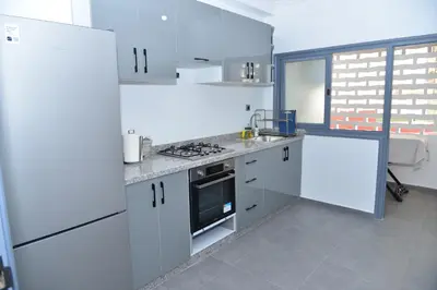 a kitchen with white cabinets and a stove top oven at Superb appartement au centre ville in Rabat