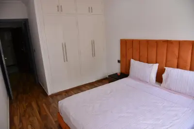 a bedroom with a bed with white sheets and white cabinets at Superb appartement au centre ville in Rabat