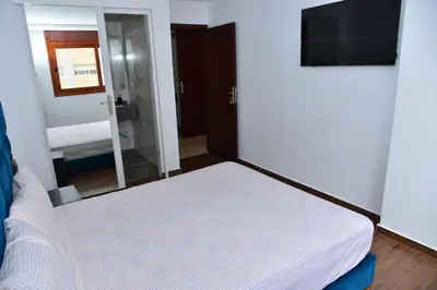 a small bedroom with a bed and a mirror at Bel appartement au cœur de rabat in Rabat