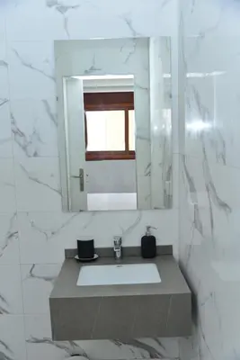 a bathroom with a sink and a mirror at Bel appartement au cœur de rabat in Rabat