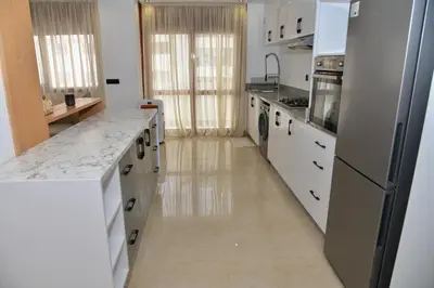 a kitchen with white counters and a refrigerator at Bel appartement au cœur de rabat in Rabat