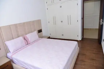 a bedroom with a large bed with pink pillows at Bel appartement au cœur de rabat in Rabat