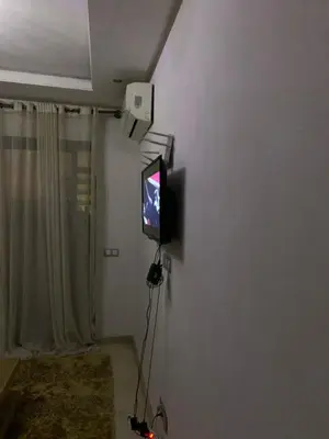 a television on a wall in a living room at appartement de antoine in Maarif