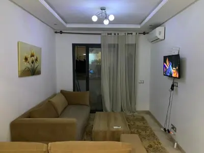 a living room with a couch and a tv at appartement de antoine in Maarif
