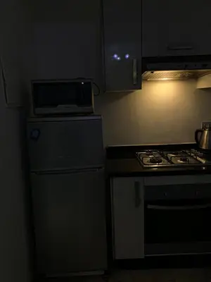 a small kitchen with a stove and a microwave at appartement de antoine in Maarif