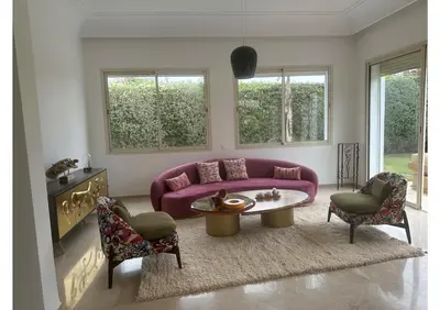 a living room with a purple couch and a table at Villa luxe avec piscine in Oulad Hamida