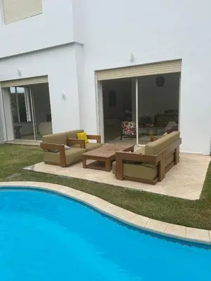 a swimming pool in front of a house at Villa luxe avec piscine in Oulad Hamida