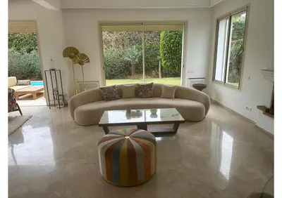 a living room with a couch and a coffee table at Villa luxe avec piscine in Oulad Hamida