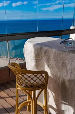 a chair sitting in front of a table with the ocean at Royal Senior Suite 3Bd & 3Ba -By Appart Ayla in Casablanca-Port