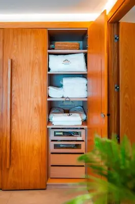 a closet with wooden cabinets and white towels at Royal Senior Suite 3Bd & 3Ba -By Appart Ayla in Casablanca-Port