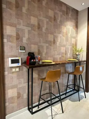 a bar with two chairs and a microwave on a wall at Studio luxueux bien meublé in Casablanca