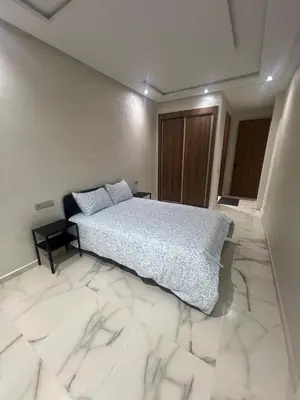 a bedroom with a bed and a tiled floor at Bel appartement à louer sur bouznika de 117 m2 in Bouznika