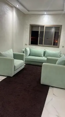 a living room with two couches and a window at Bel appartement à louer sur bouznika de 117 m2 in Bouznika