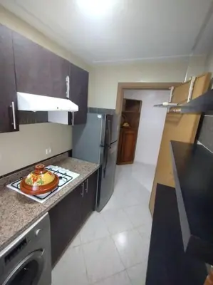 a kitchen with a sink and a stove top oven at Appartement très propre lumineux en moyen standing a résidence klk darbouza in Casablanca