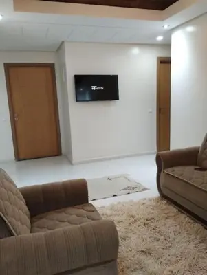 a living room with two couches and a flat screen tv at Appartement très propre lumineux en moyen standing a résidence klk darbouza in Casablanca