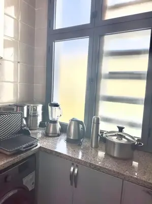 a kitchen counter with pots and pans and a window at Bel Appartement vue piscine in Mansouria