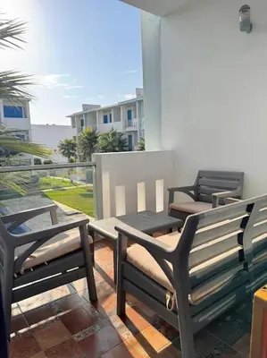 three benches sitting on a patio with a view of the ocean at Bel Appartement vue piscine in Mansouria