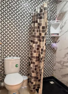 a bathroom with a toilet and a shower curtain at Bel Appartement vue piscine in Mansouria